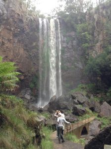 people looking up at a waterfall